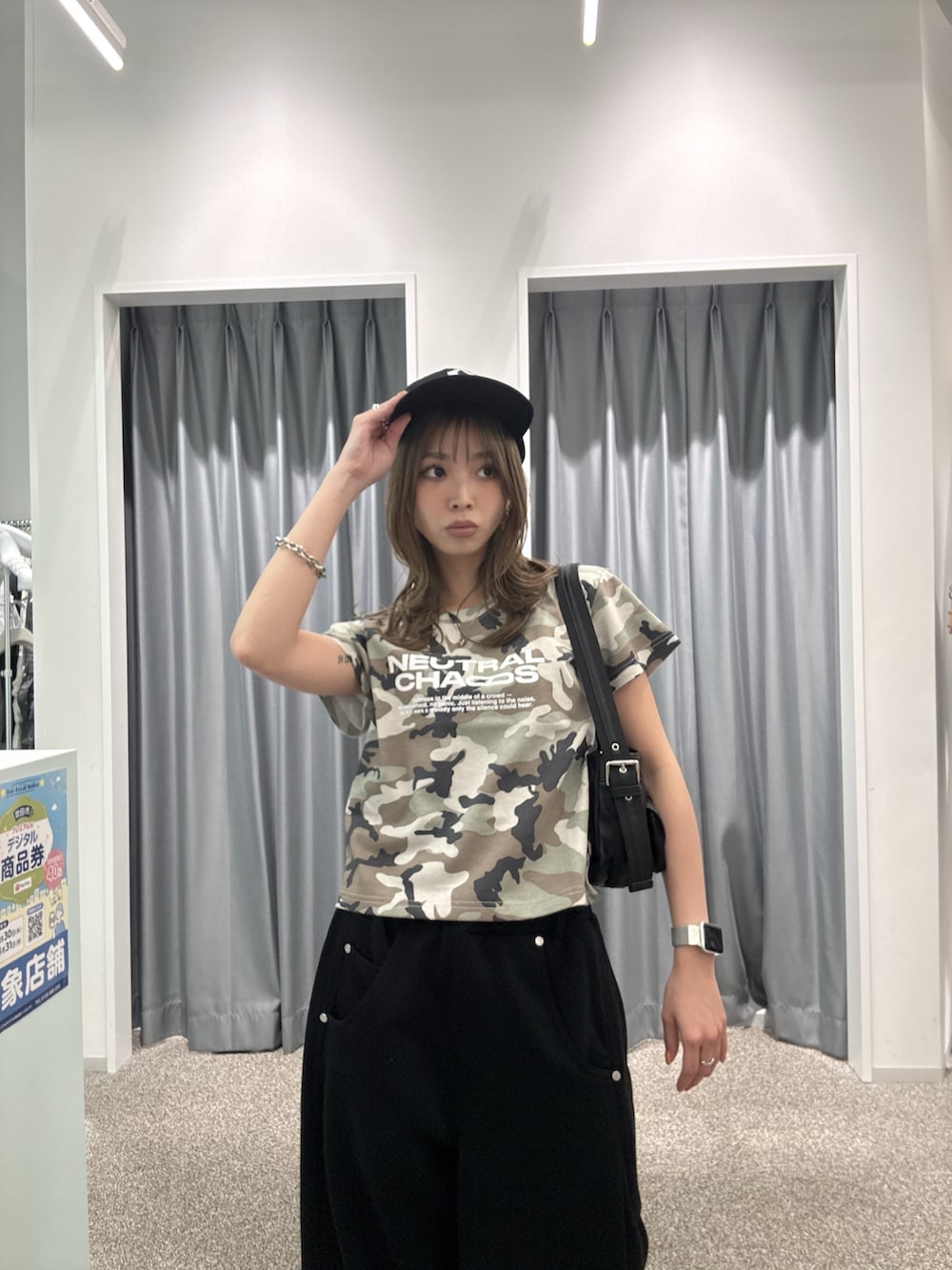 ブラック系のスウェットパンツ、ブラック系のハンドバッグ、グリーン系のTシャツ/カットソーを着用したレディースの春コーディネートの3枚目の写真
