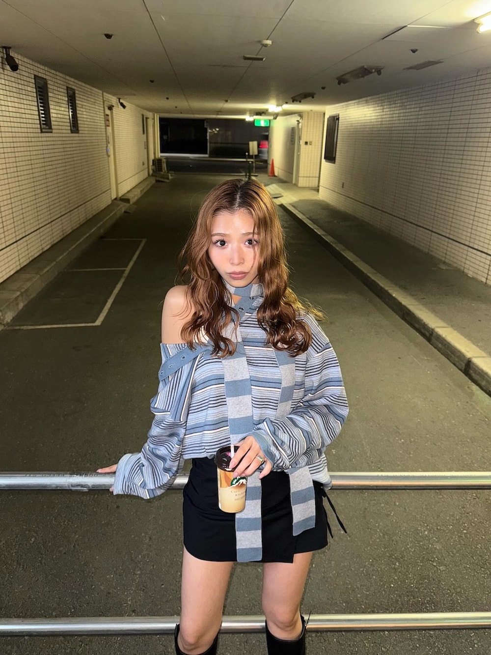 ブラック系のスカート、ブルー系のニット/セーターを着用したレディースの秋コーディネートの3枚目の写真