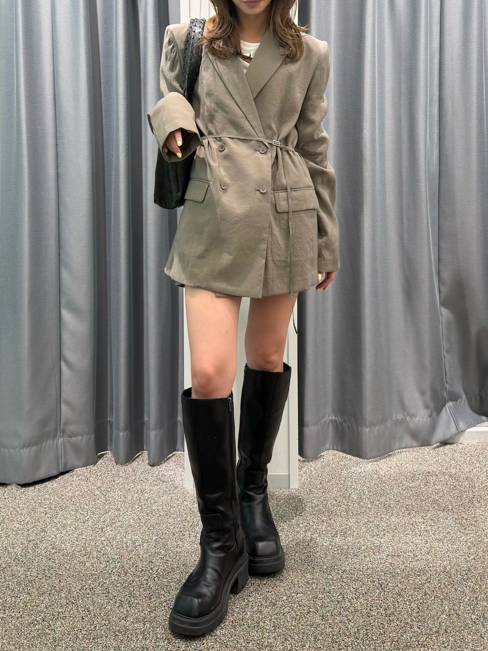 ブラック系のブーツ、ブラック系のハンドバッグ、ホワイト系のTシャツ/カットソーを着用したレディースの春コーディネートの2枚目の写真