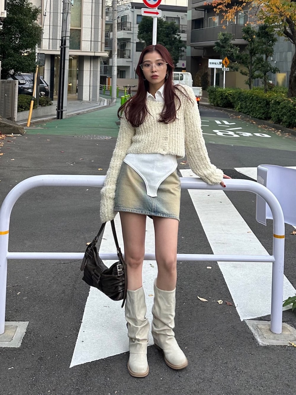 ブラウン系のハンドバッグ、ホワイト系のカーディガン/ボレロ、ホワイト系のニット/セーターを着用したレディースの冬コーディネートの2枚目の写真