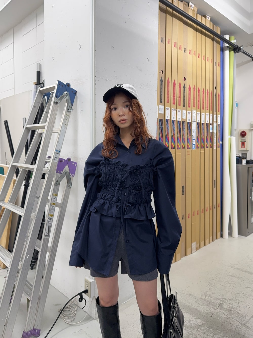 ブラック系のブーツ、ブラック系のショルダーバッグ、ブルー系のシャツ/ブラウスを着用したレディースの夏コーディネートの3枚目の写真