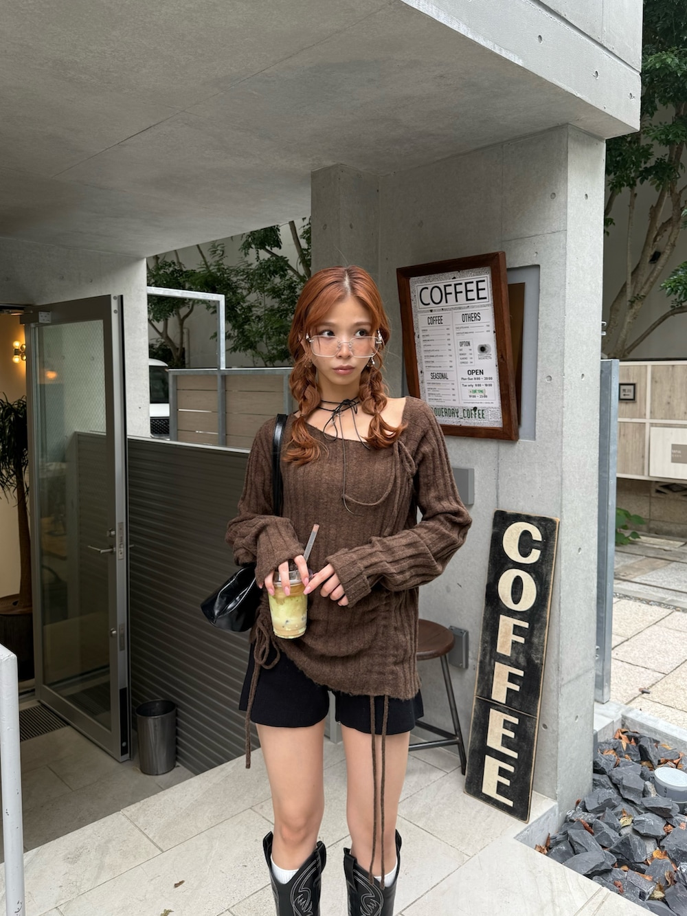 ブラック系のスラックス、ブラック系のショルダーバッグ、ブラック系のチョーカーを着用したレディースの秋コーディネートの2枚目の写真