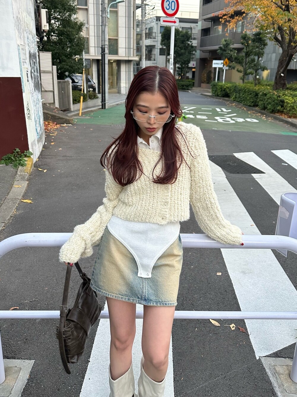 ブラウン系のハンドバッグ、ホワイト系のカーディガン/ボレロ、ホワイト系のニット/セーターを着用したレディースの冬コーディネートの4枚目の写真