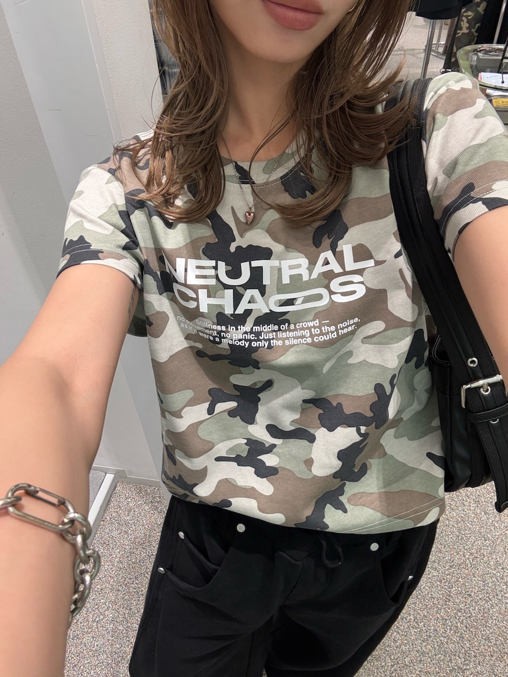 ブラック系のスウェットパンツ、ブラック系のハンドバッグ、グリーン系のTシャツ/カットソーを着用したレディースの春コーディネートの4枚目の写真