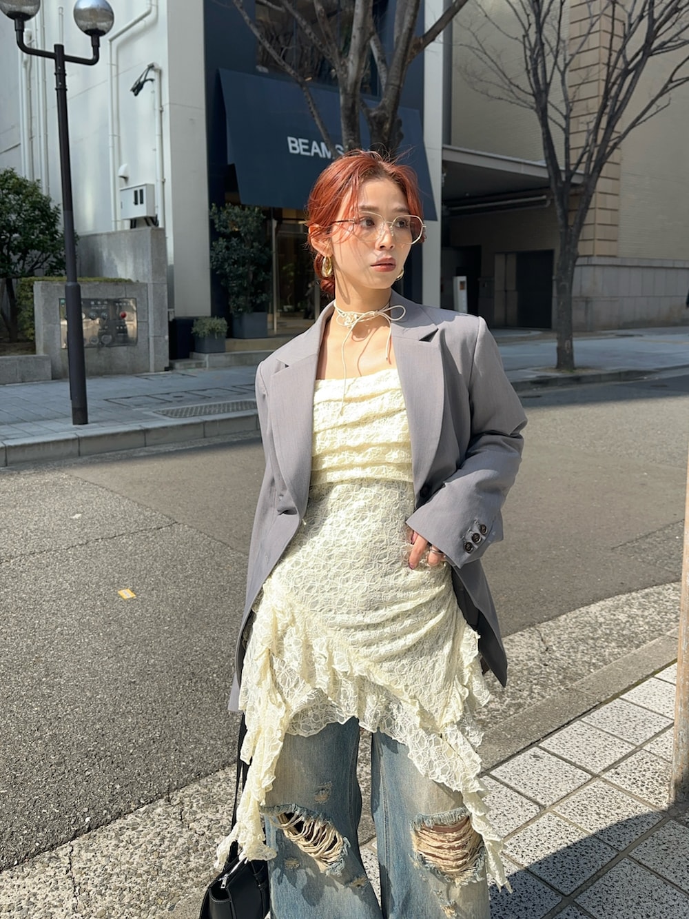 ホワイト系のワンピース、ブルー系のデニムパンツ、グレー系のテーラードジャケットを着用したレディースの冬コーディネートの2枚目の写真