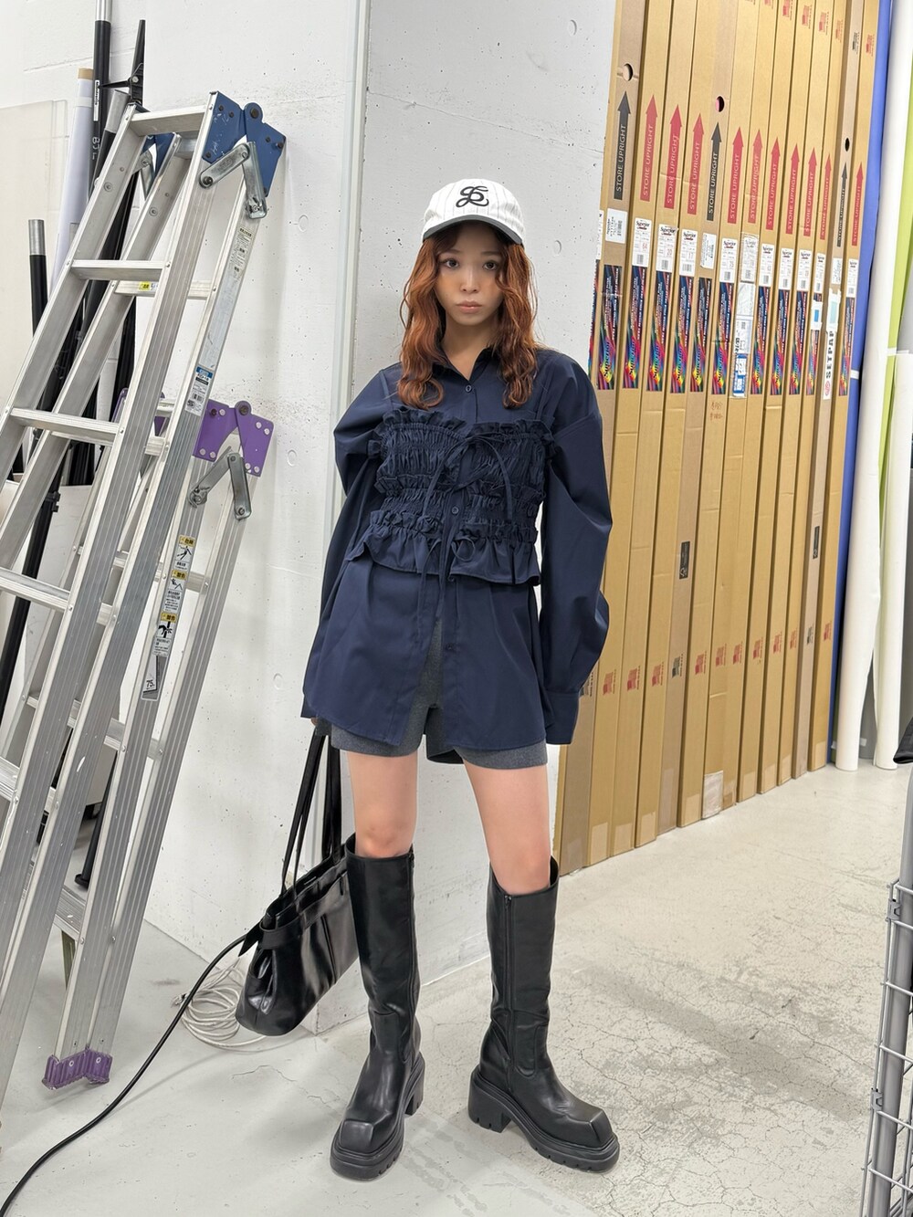 ブラック系のブーツ、ブラック系のショルダーバッグ、ブルー系のシャツ/ブラウスを着用したレディースの夏コーディネートの2枚目の写真