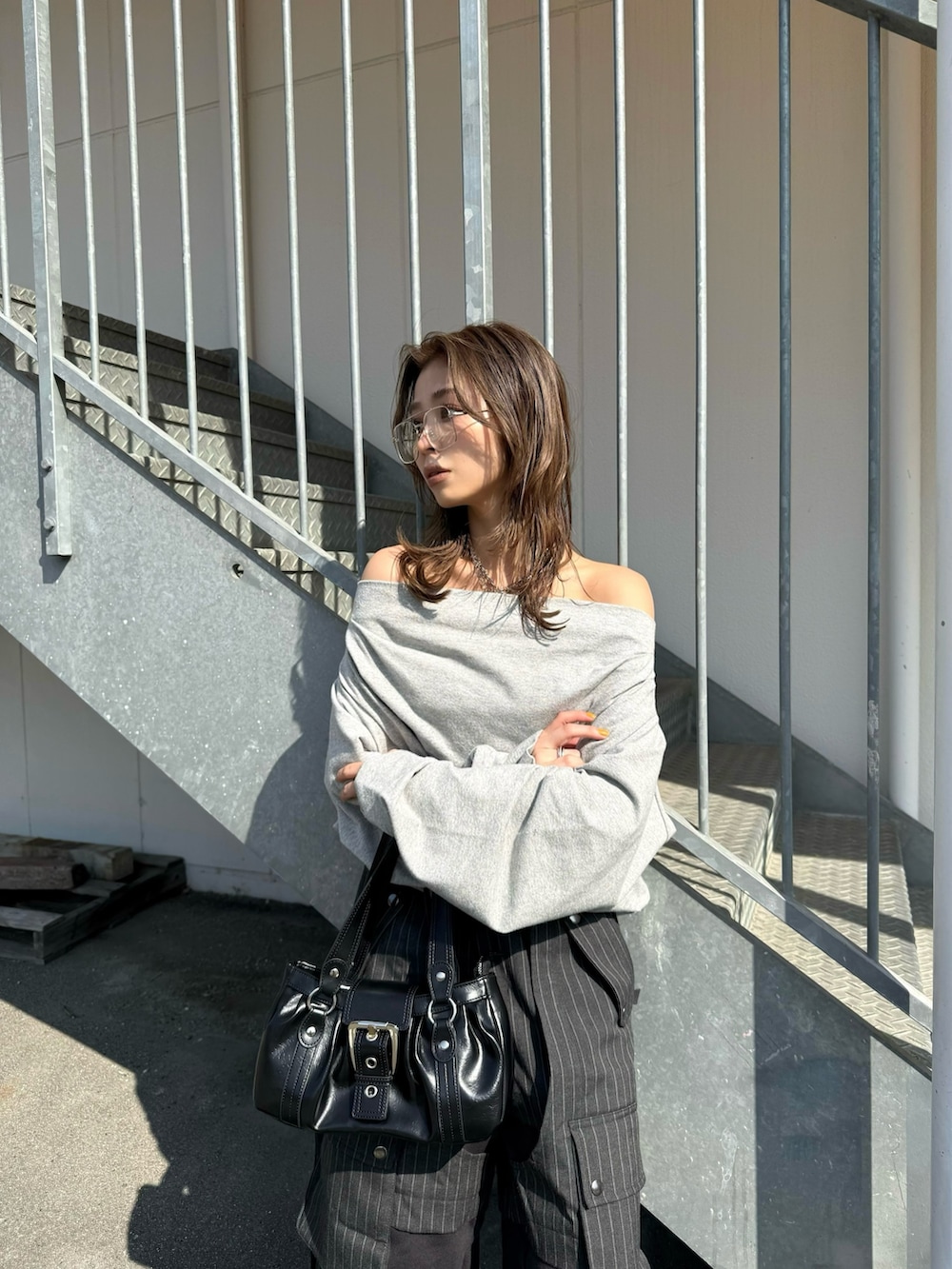 グレー系のスウェット、グレー系のカーゴパンツ、ブラック系のスニーカーを着用したレディースの冬コーディネートの2枚目の写真