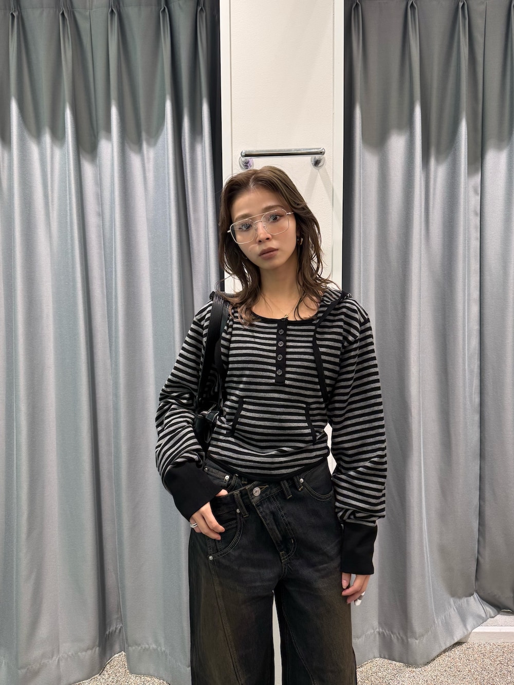 ブラック系のカーディガン/ボレロ、ブラック系のTシャツ/カットソー、ブルー系のデニムパンツを着用したレディースの春コーディネートの2枚目の写真