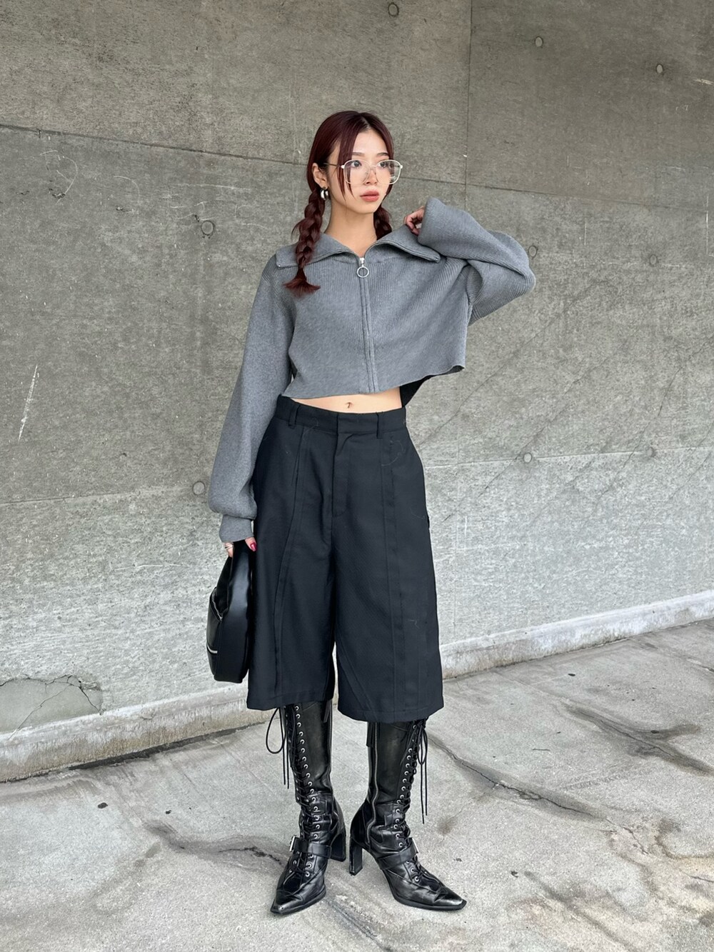 ブラック系のブーツ、ブラック系のスラックス、グレー系のニット/セーターを着用したレディースの秋コーディネートの2枚目の写真