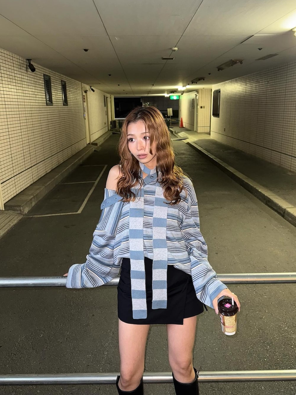 ブラック系のスカート、ブルー系のニット/セーターを着用したレディースの秋コーディネートの2枚目の写真