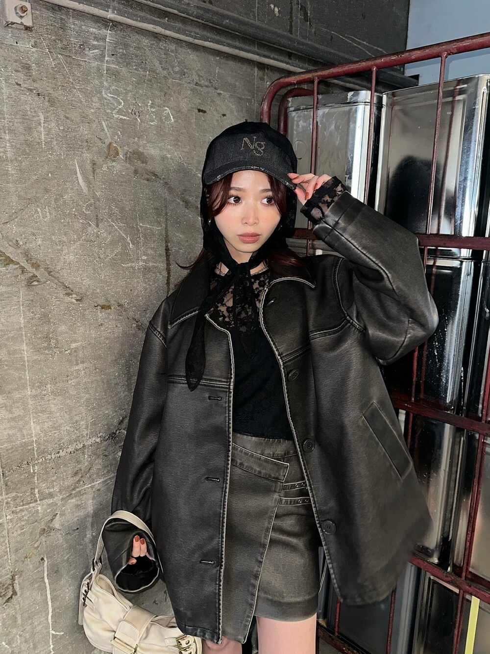 ブラック系のブーツ、ホワイト系のハンドバッグ、ブラック系のTシャツ/カットソーを着用したレディースの冬コーディネートの2枚目の写真