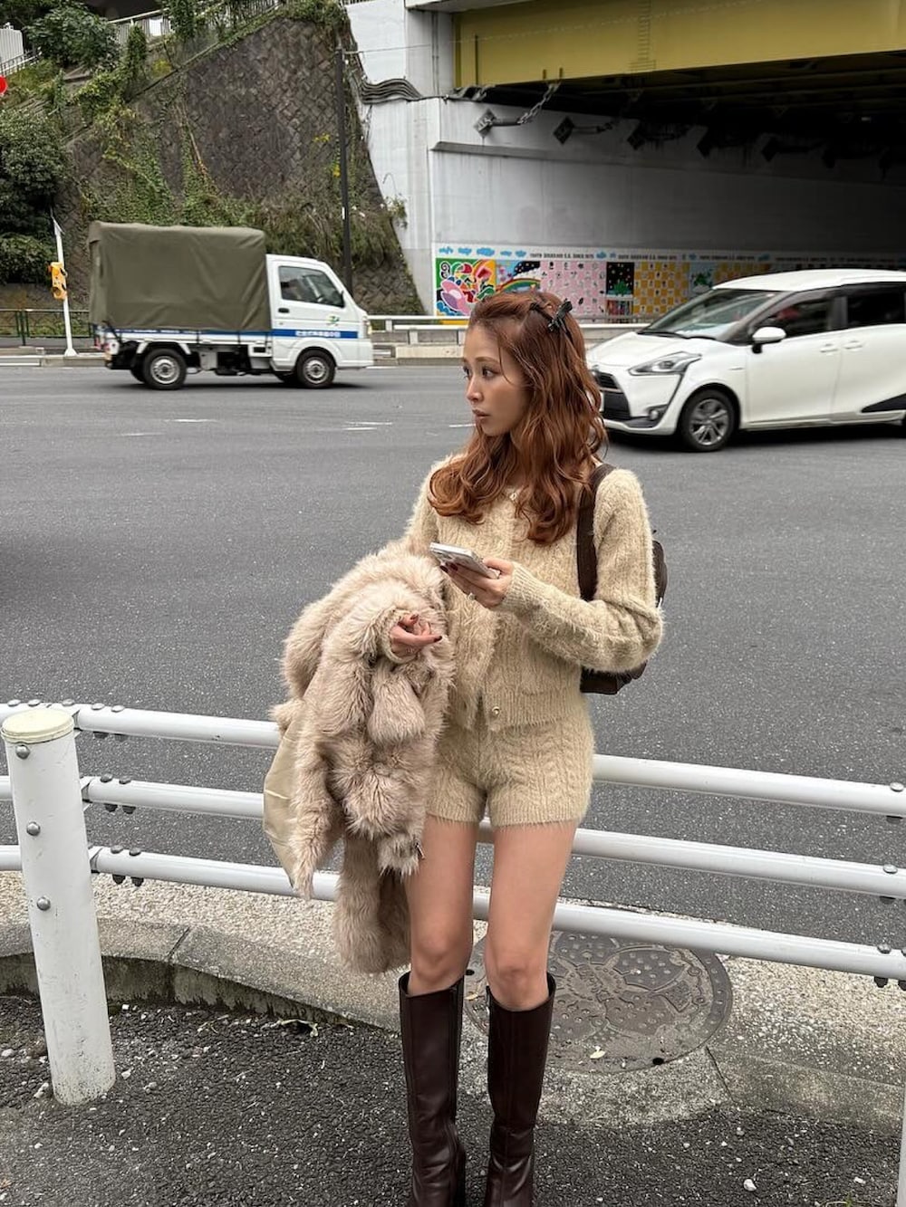 ホワイト系のカーディガン/ボレロ、ホワイト系のスラックス、ブラウン系のブーツを着用したレディースの秋コーディネートの2枚目の写真