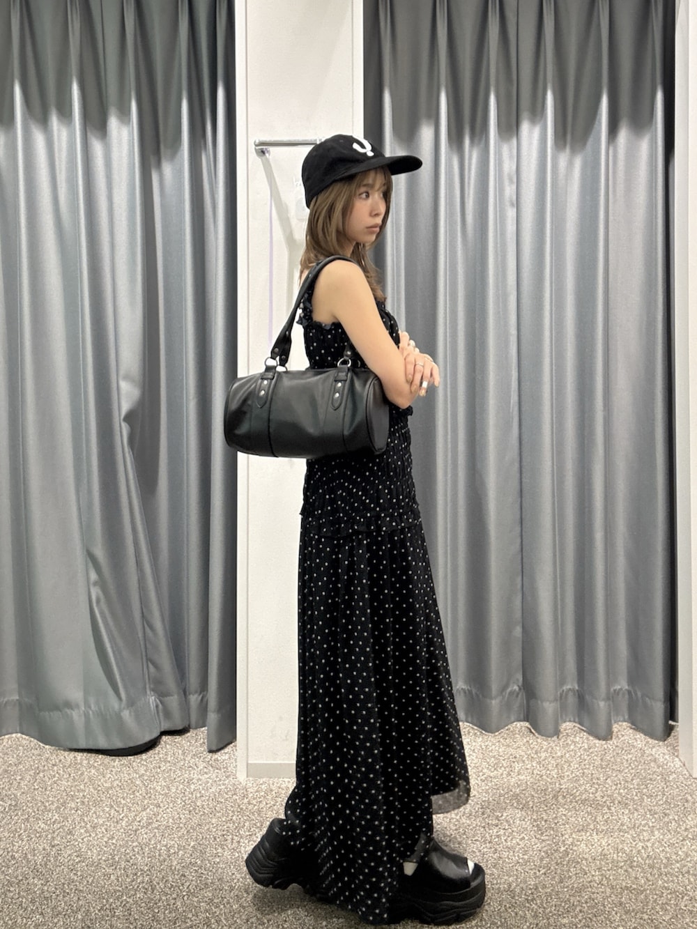 ブラック系のワンピース、ブラック系のハンドバッグ、ブラック系のサンダルを着用したレディースの夏コーディネートの2枚目の写真