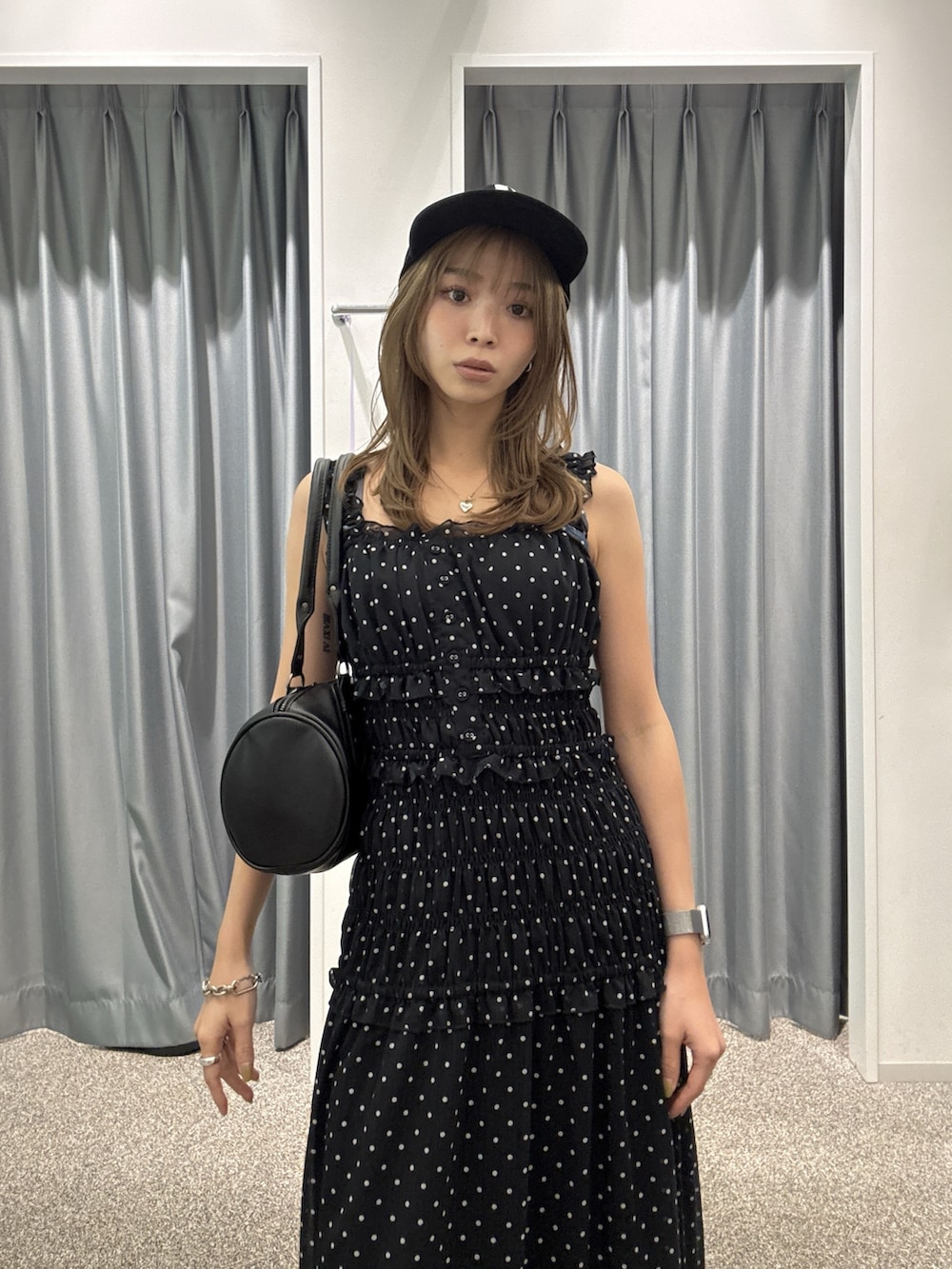 ブラック系のワンピース、ブラック系のハンドバッグ、ブラック系のサンダルを着用したレディースの夏コーディネートの3枚目の写真