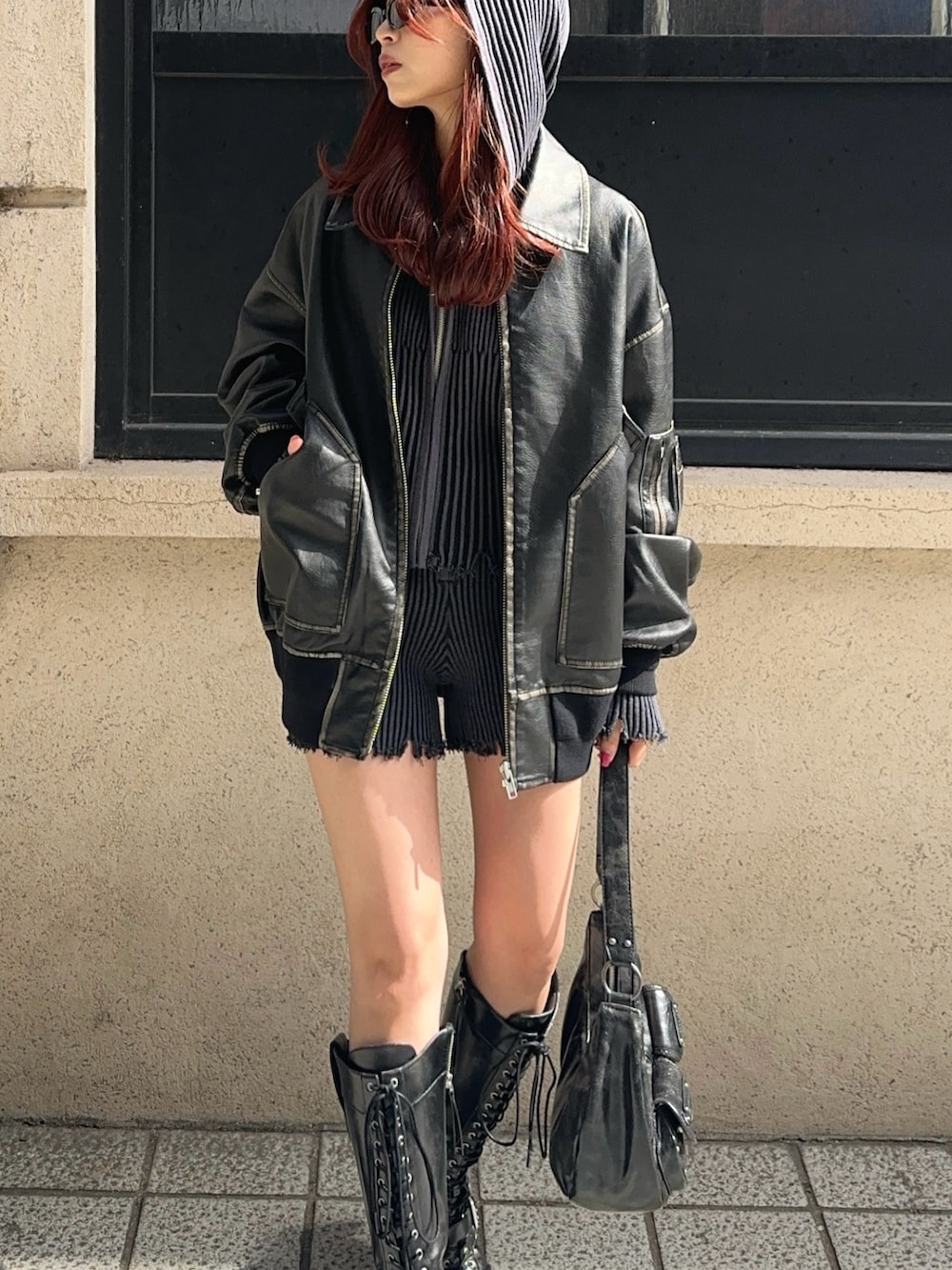 ブラック系のブルゾン、ブラック系のスラックス、ブラック系のパーカーを着用したレディースの秋コーディネートの3枚目の写真