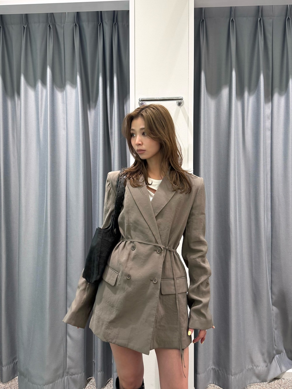 ブラック系のブーツ、ブラック系のハンドバッグ、ホワイト系のTシャツ/カットソーを着用したレディースの春コーディネートの3枚目の写真