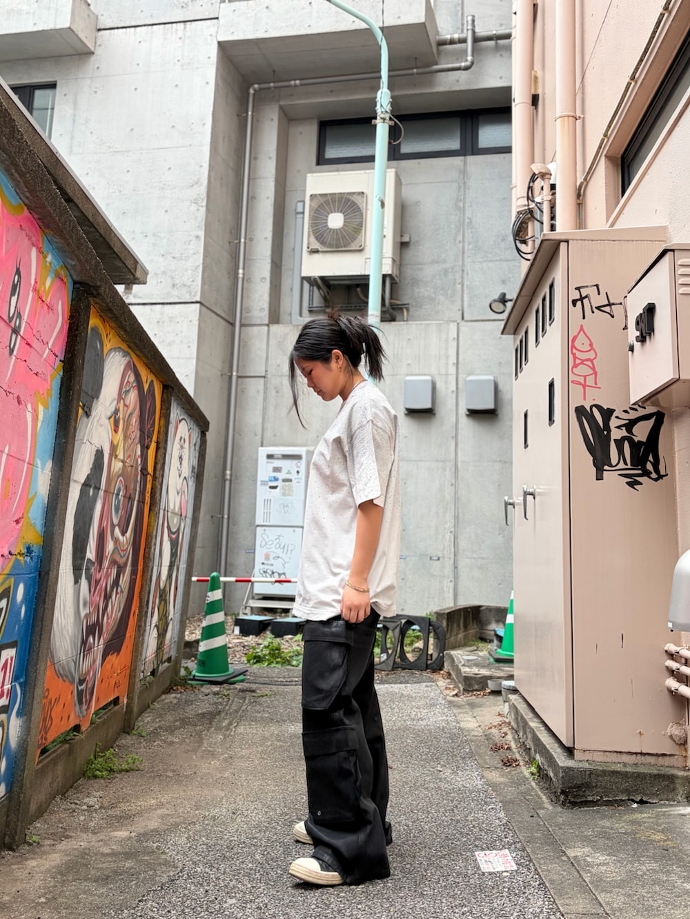 ホワイト系のTシャツ/カットソー、ブラック系のカーゴパンツを着用したレディースの春コーディネートの2枚目の写真