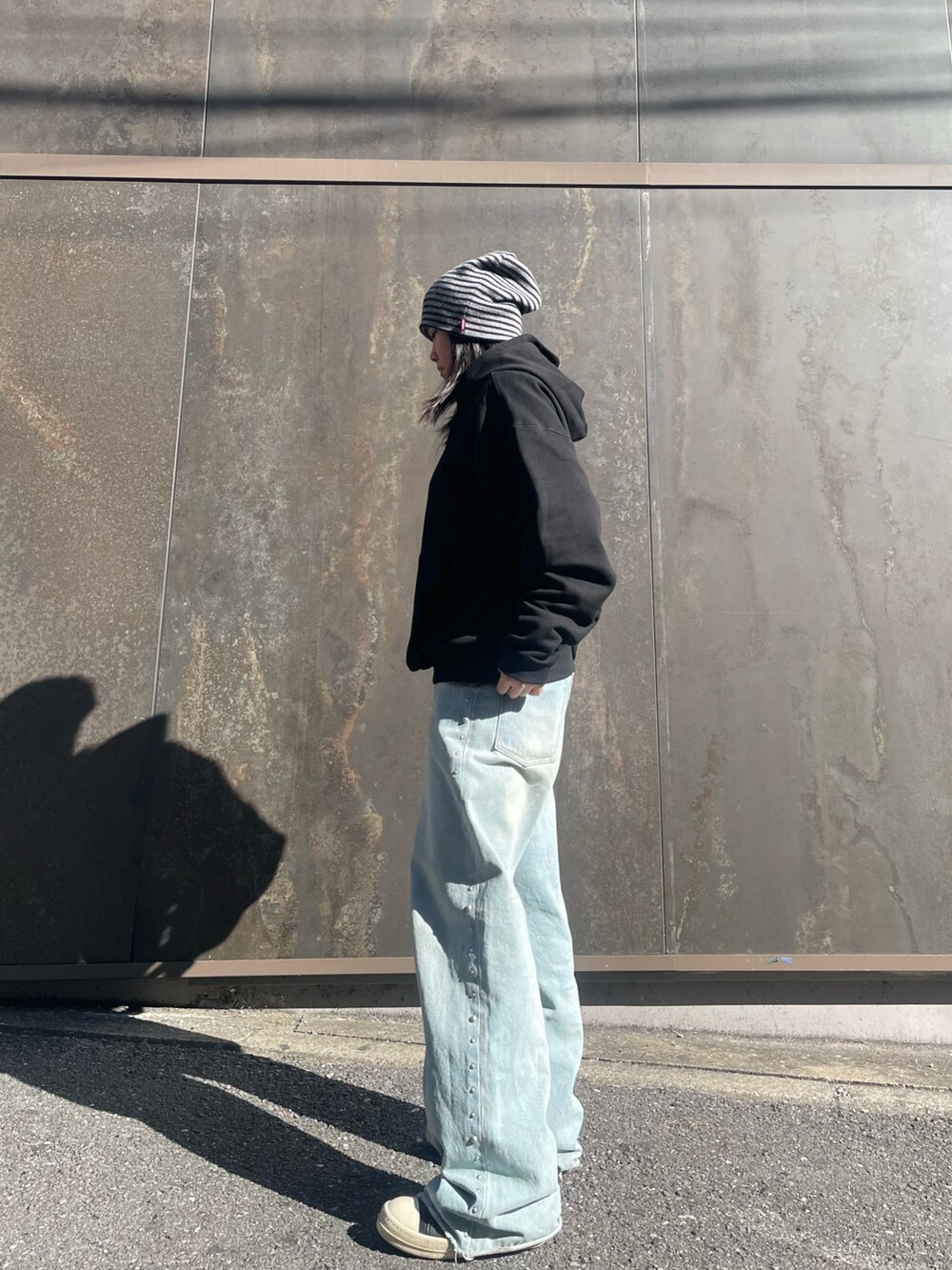 ブラック系のパーカーを着用したレディースの冬コーディネートの2枚目の写真