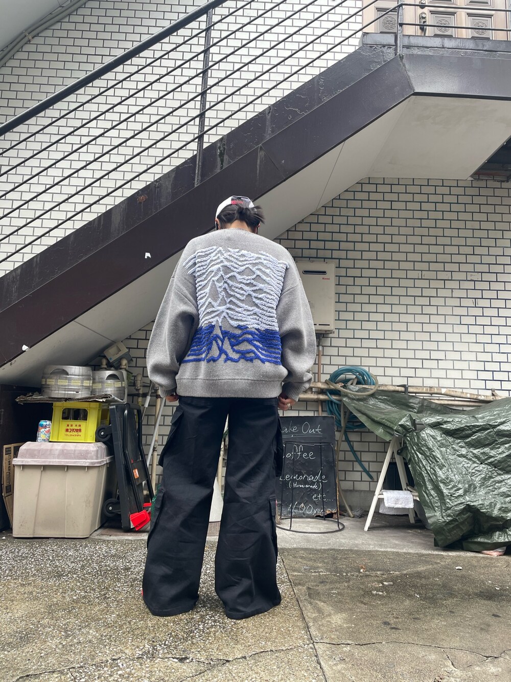 グレー系のニット/セーター、ブラック系のカーゴパンツを着用したレディースの秋コーディネートの5枚目の写真