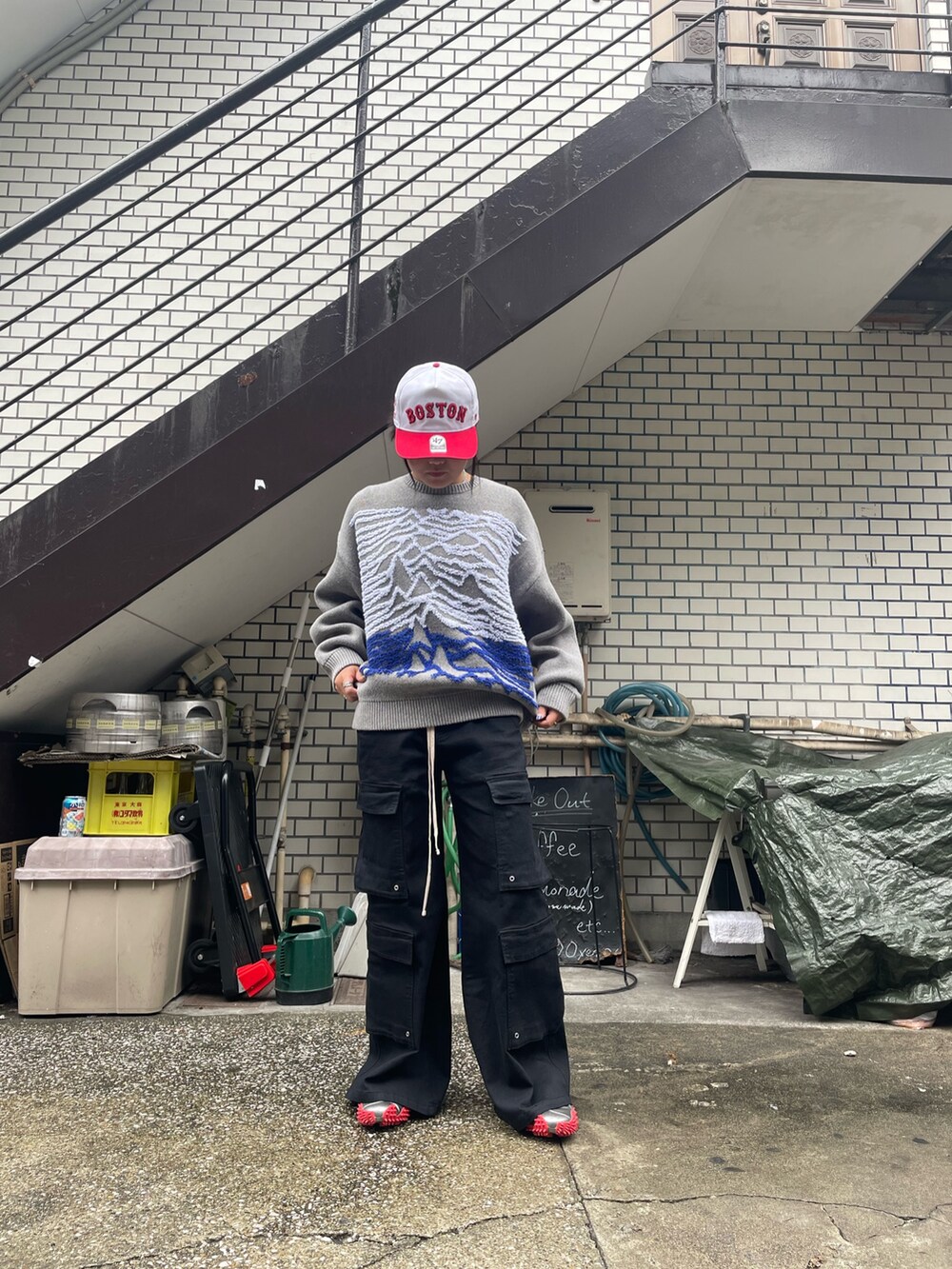 グレー系のニット/セーター、ブラック系のカーゴパンツを着用したレディースの秋コーディネートの2枚目の写真