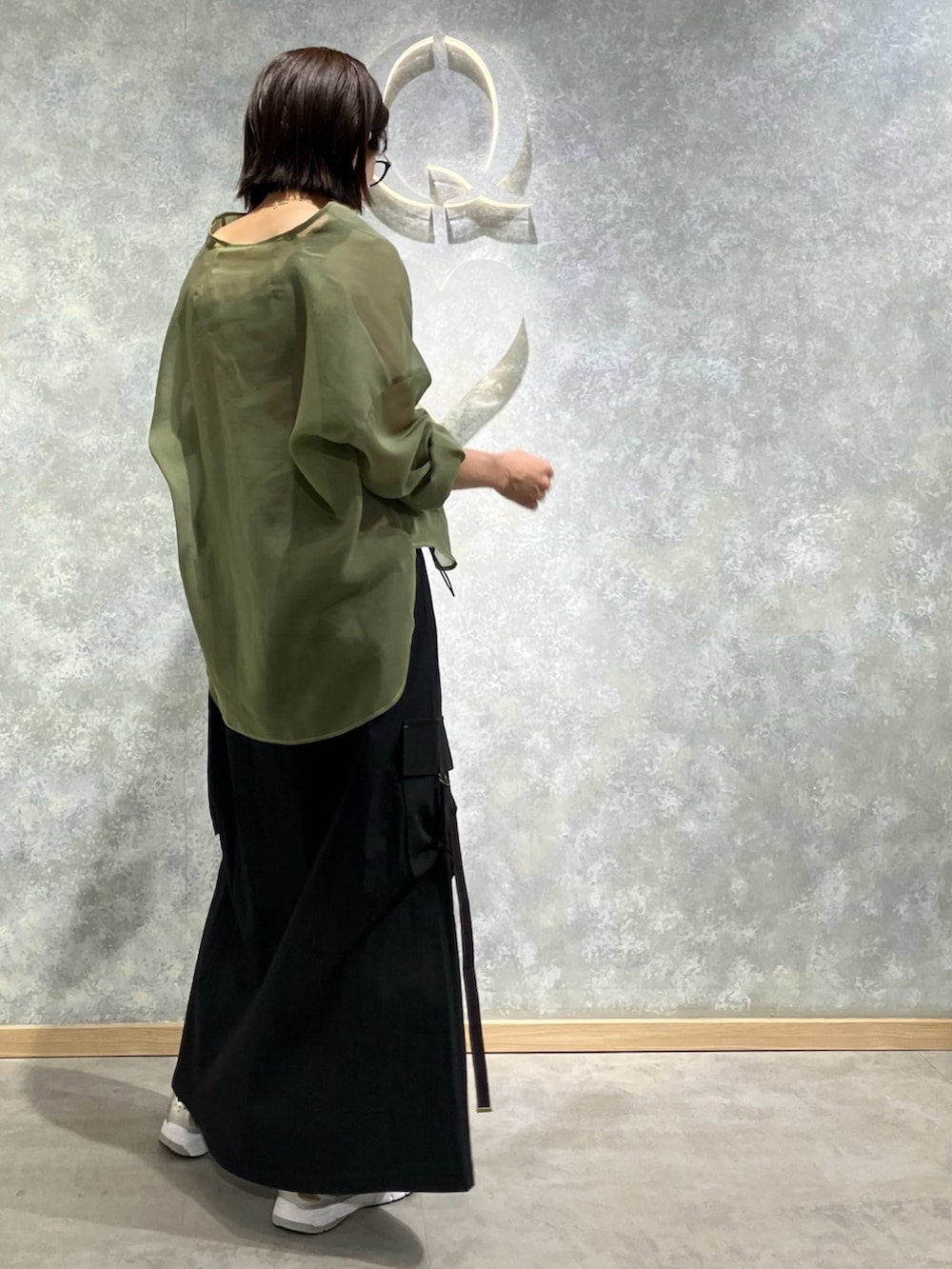 グリーン系のシャツ/ブラウス、ブラック系のジャンパースカート、レッド系のタンクトップを着用したレディースの秋コーディネートの3枚目の写真