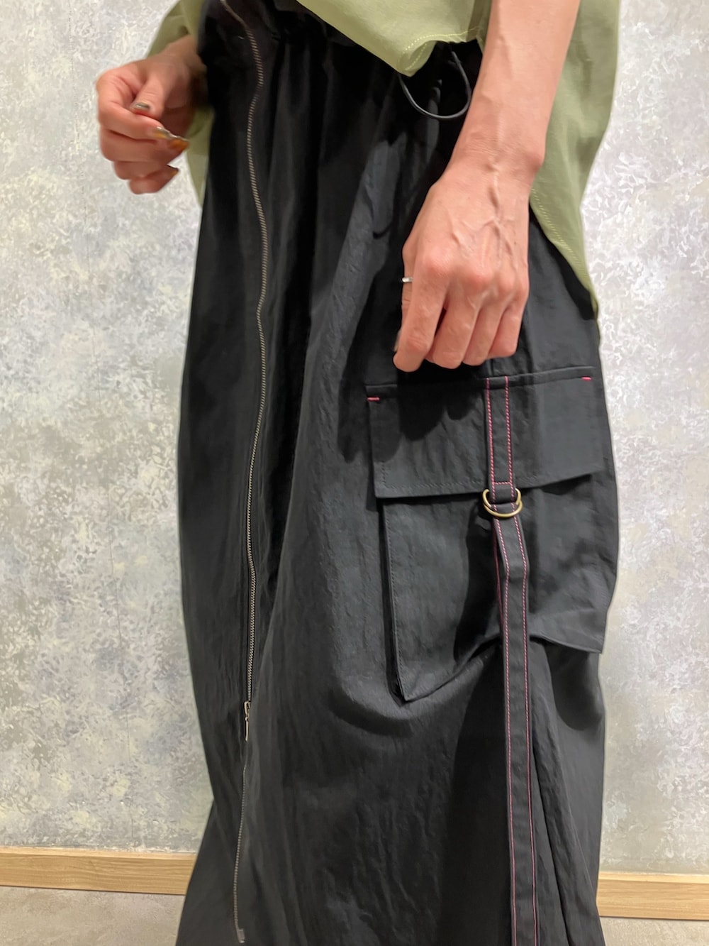 グリーン系のシャツ/ブラウス、ブラック系のジャンパースカート、レッド系のタンクトップを着用したレディースの秋コーディネートの2枚目の写真