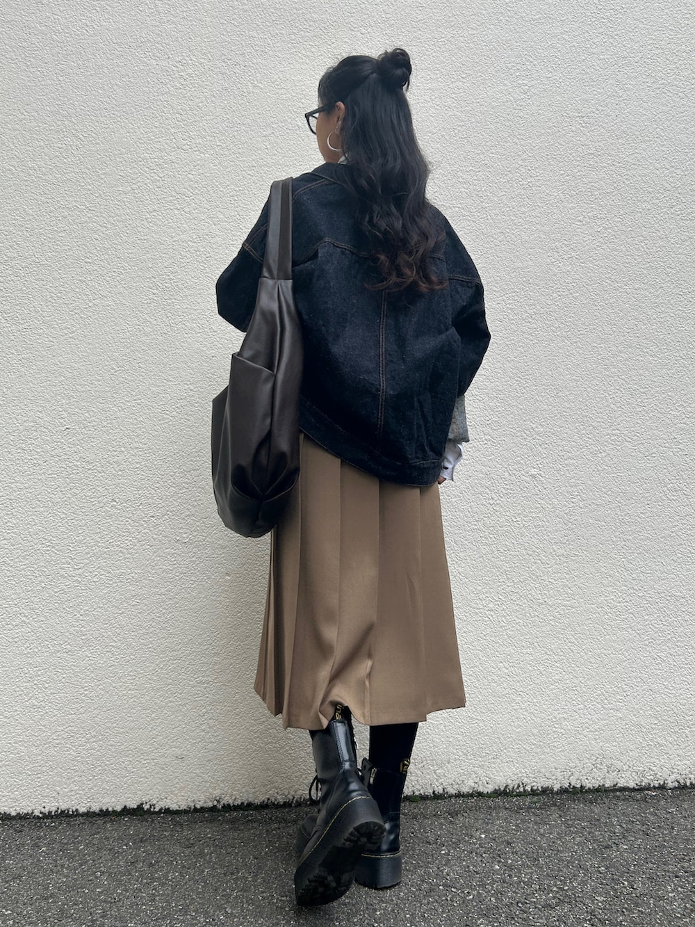 ベージュ系のスカート、ブラウン系のショルダーバッグ、ブルー系のデニムジャケットを着用したレディースの秋コーディネートの3枚目の写真