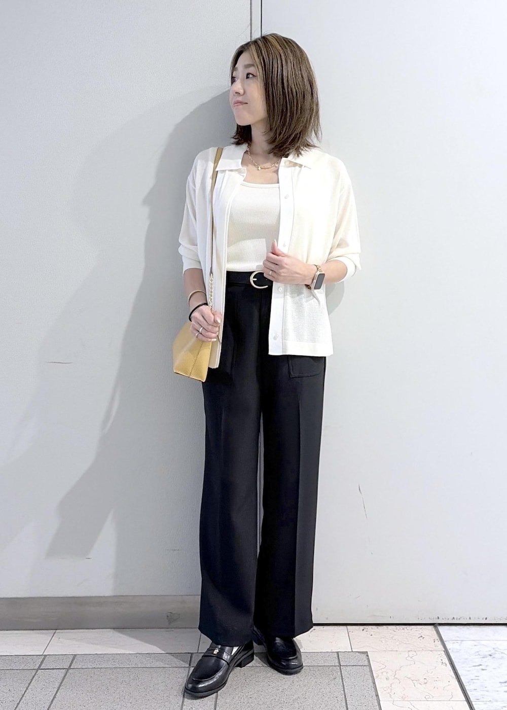 ブラウン系のショルダーバッグ、ブラック系のローファー、ブラック系のその他パンツを着用したレディースの春コーディネートの5枚目の写真