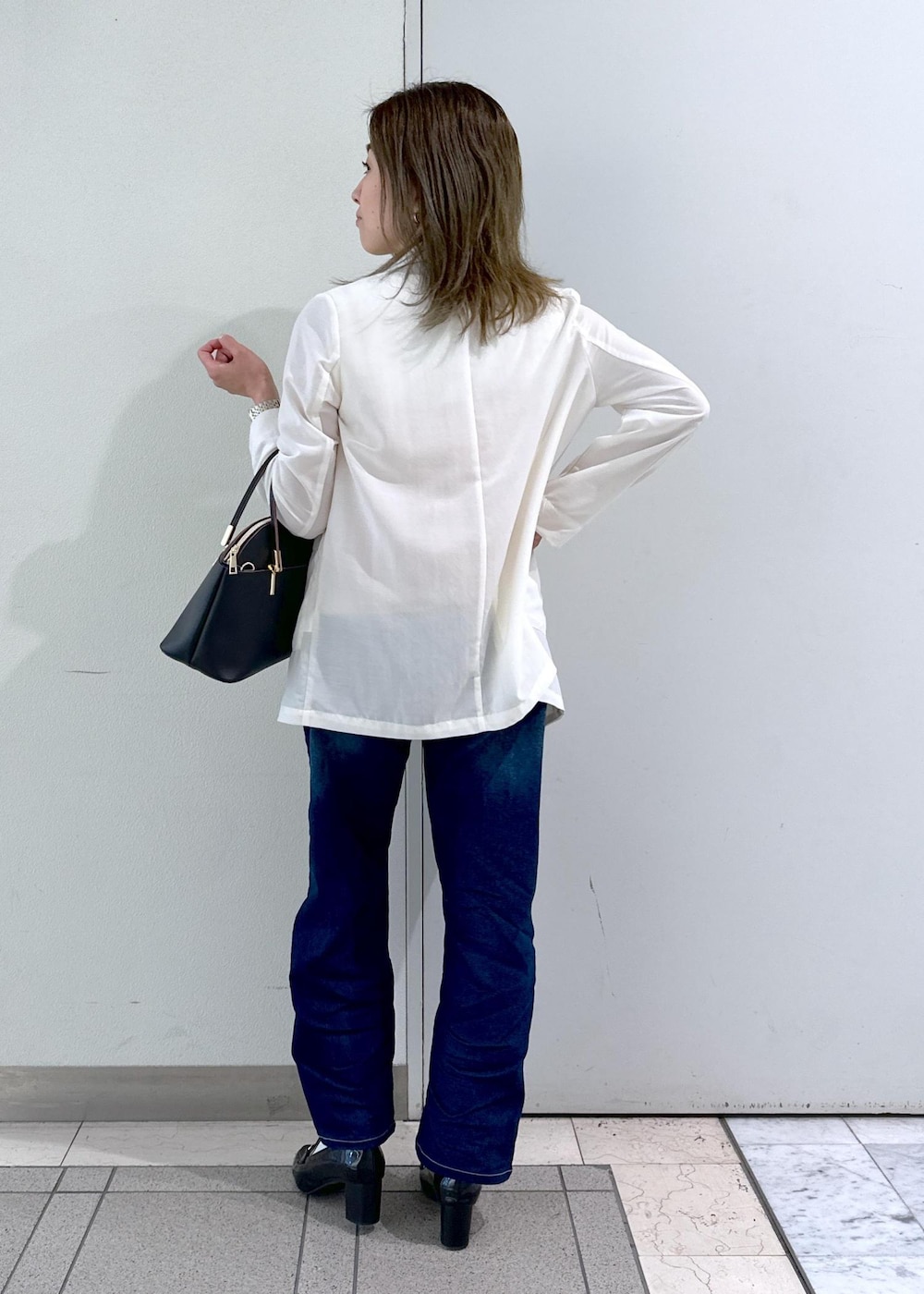 ブラック系のローファー、ベージュ系のTシャツ/カットソー、ホワイト系のテーラードジャケットを着用したレディースの春コーディネートの3枚目の写真