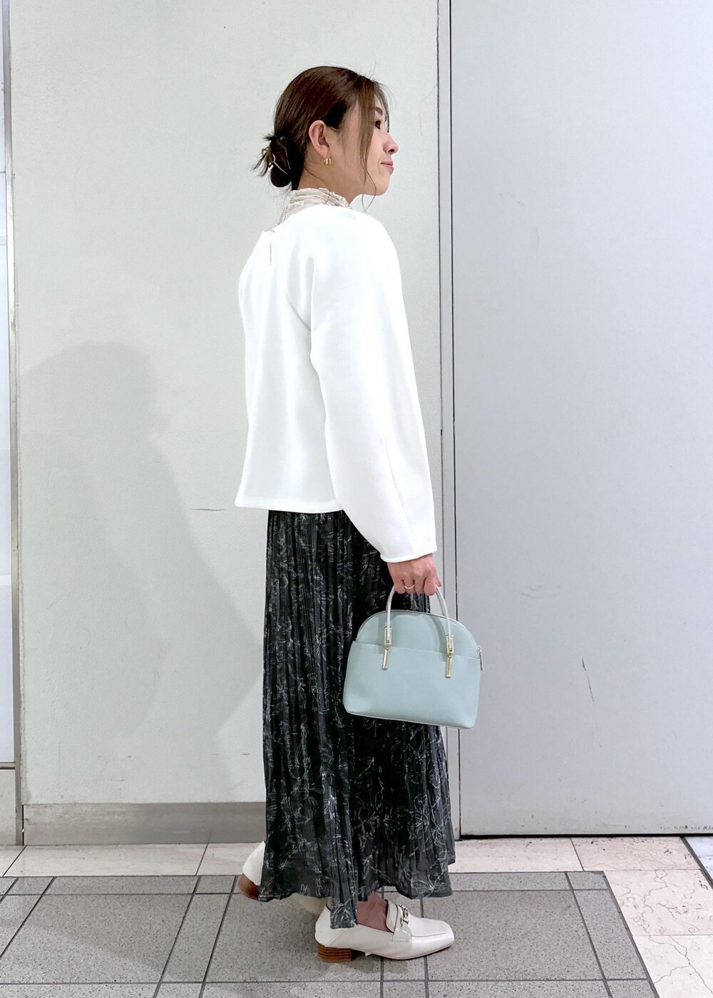 ホワイト系のTシャツ/カットソー、ホワイト系のローファー、グレー系のスカートを着用したレディースの冬コーディネートの2枚目の写真