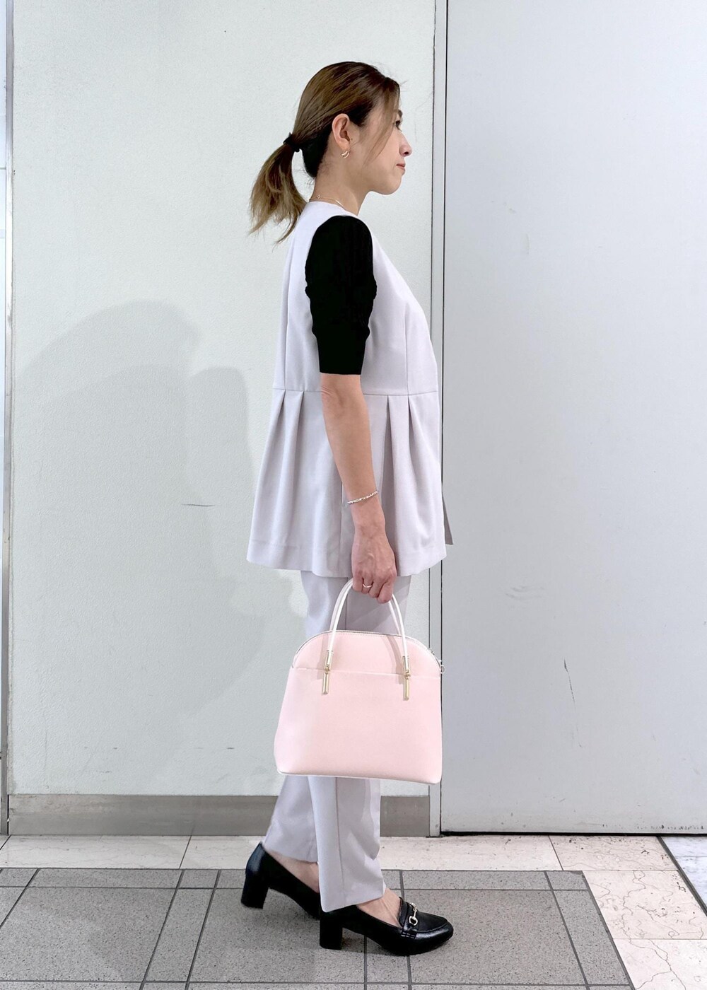 ピンク系のショルダーバッグ、ブラック系のローファー、ブラック系のタンクトップを着用したレディースの春コーディネートの4枚目の写真