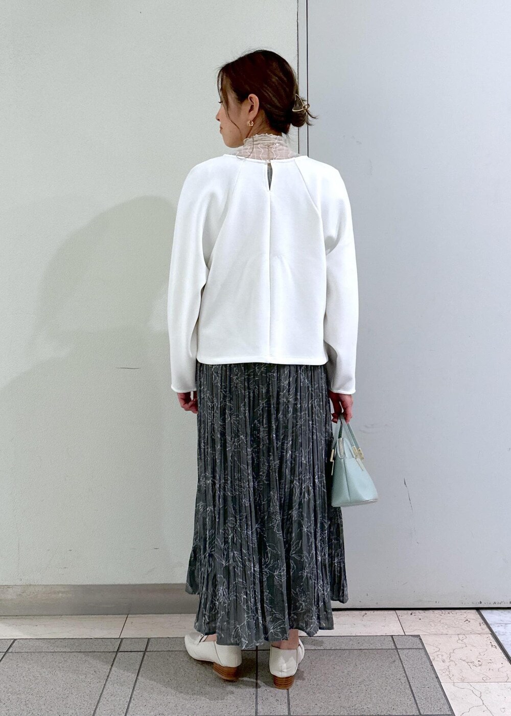 ホワイト系のTシャツ/カットソー、ホワイト系のローファー、グレー系のスカートを着用したレディースの冬コーディネートの3枚目の写真