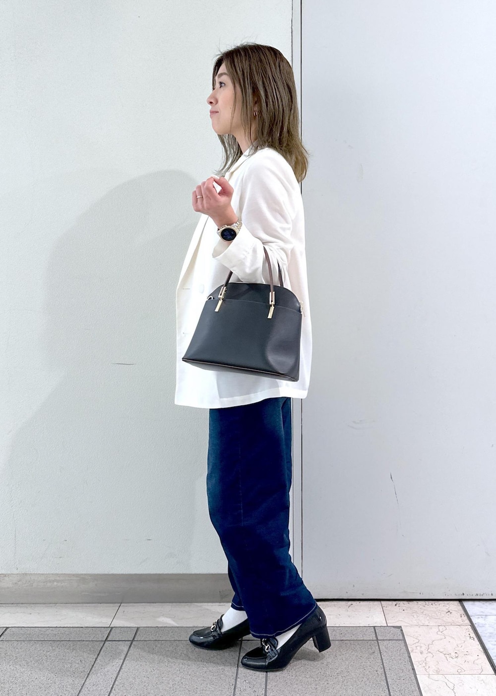 ブラック系のローファー、ベージュ系のTシャツ/カットソー、ホワイト系のテーラードジャケットを着用したレディースの春コーディネートの2枚目の写真