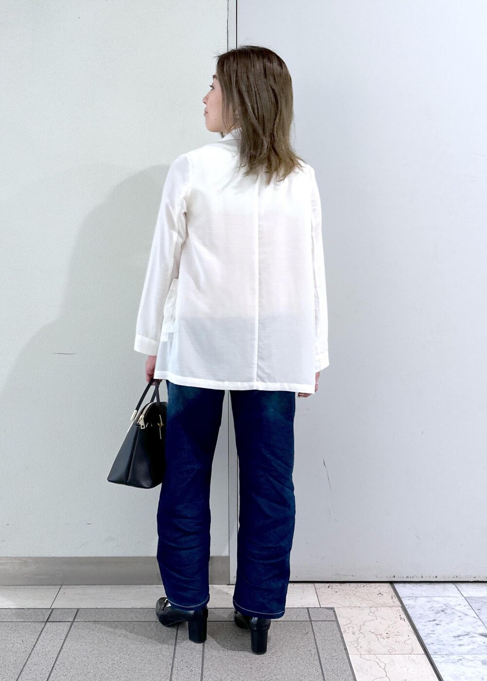 ブラック系のローファー、ベージュ系のTシャツ/カットソー、ホワイト系のテーラードジャケットを着用したレディースの春コーディネートの4枚目の写真