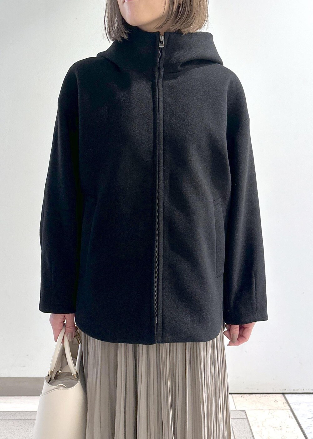 ホワイト系のニット/セーター、ブラック系のブーツ、ブラウン系のスカートを着用したレディースの冬コーディネートの10枚目の写真