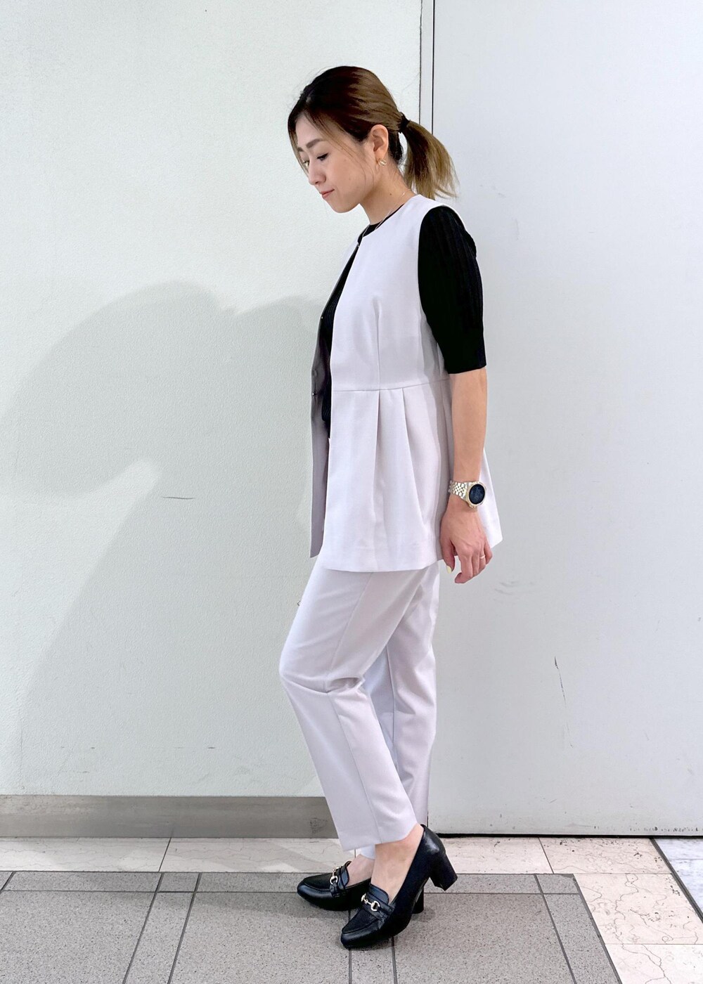 ピンク系のショルダーバッグ、ブラック系のローファー、ブラック系のタンクトップを着用したレディースの春コーディネートの2枚目の写真