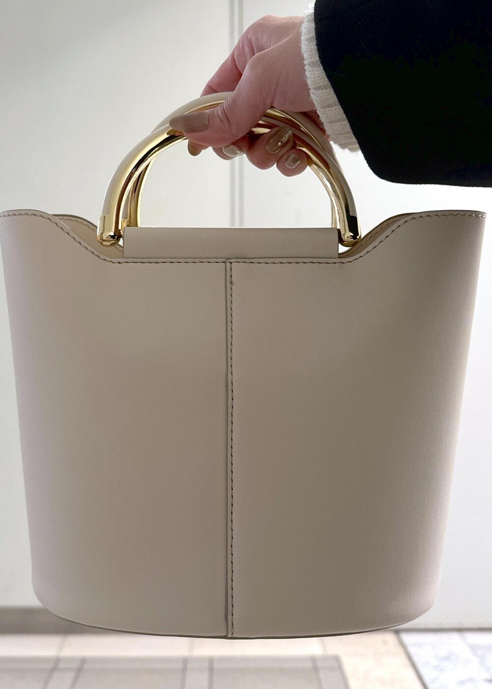 ホワイト系のニット/セーター、ブラック系のブーツ、ブラウン系のスカートを着用したレディースの冬コーディネートの9枚目の写真