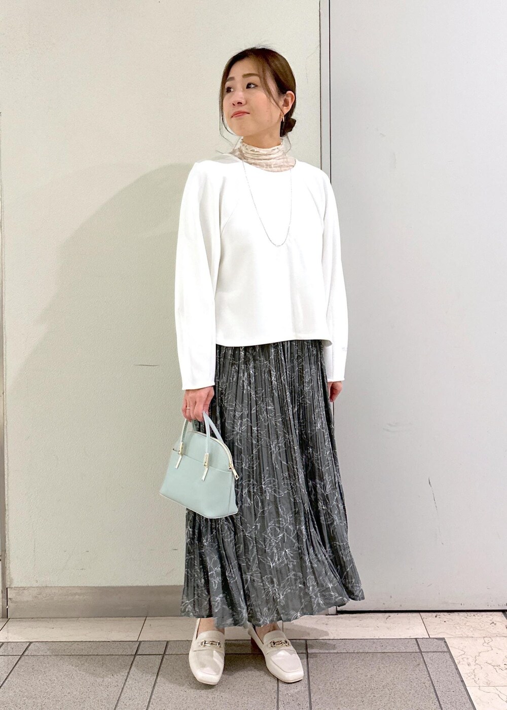 ホワイト系のTシャツ/カットソー、ホワイト系のローファー、グレー系のスカートを着用したレディースの冬コーディネートの5枚目の写真