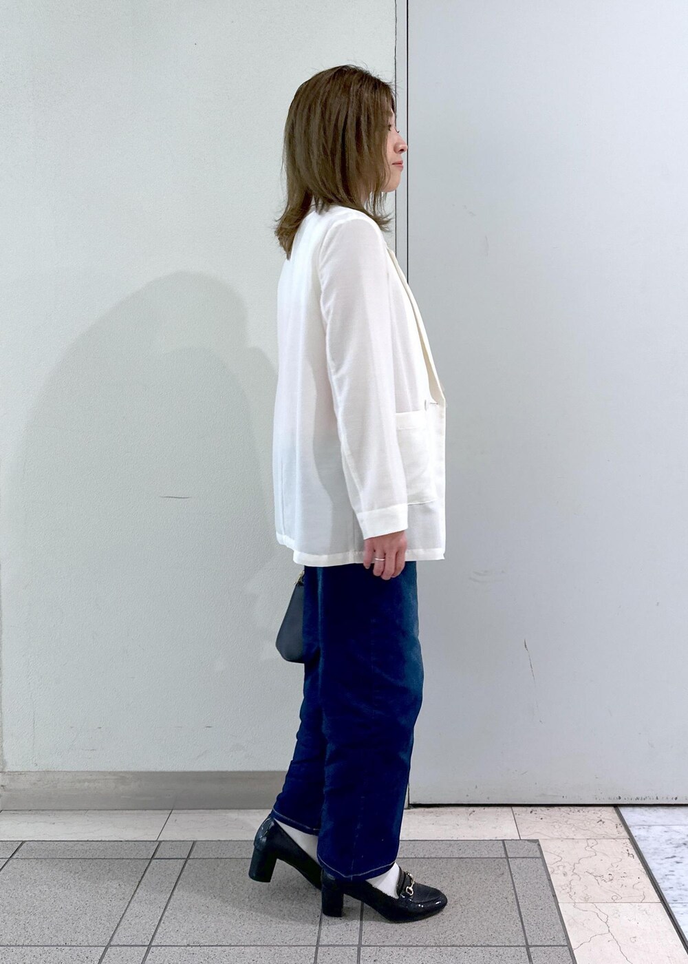 ブラック系のローファー、ベージュ系のTシャツ/カットソー、ホワイト系のテーラードジャケットを着用したレディースの春コーディネートの5枚目の写真