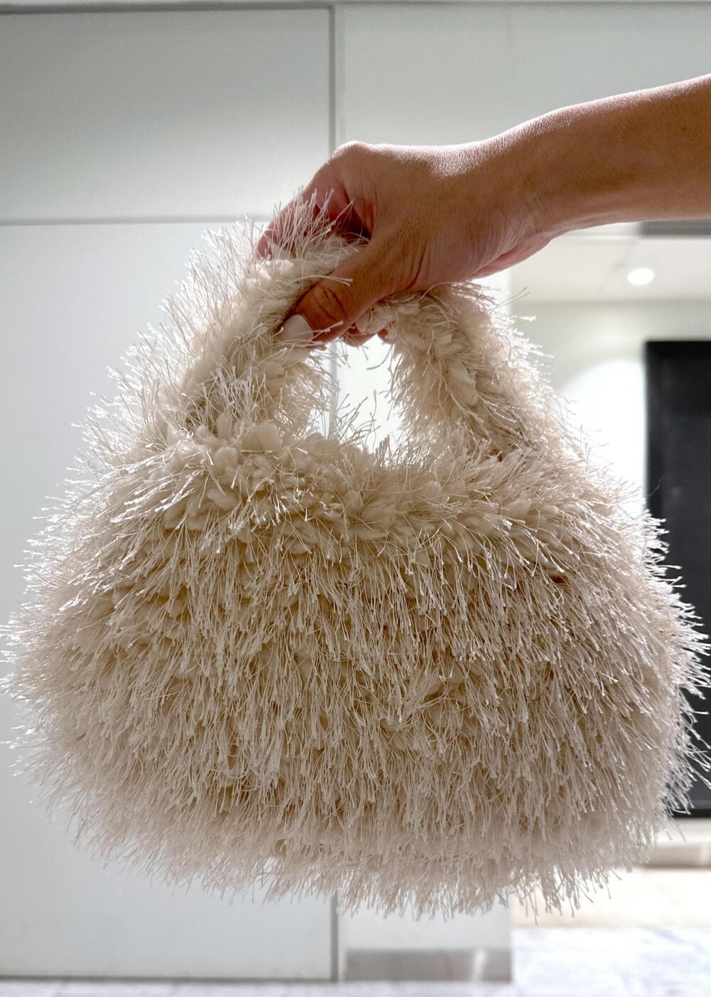 ベージュ系のハンドバッグ、ブラック系のブーツ、イエロー系のスカートを着用したレディースの秋コーディネートの10枚目の写真