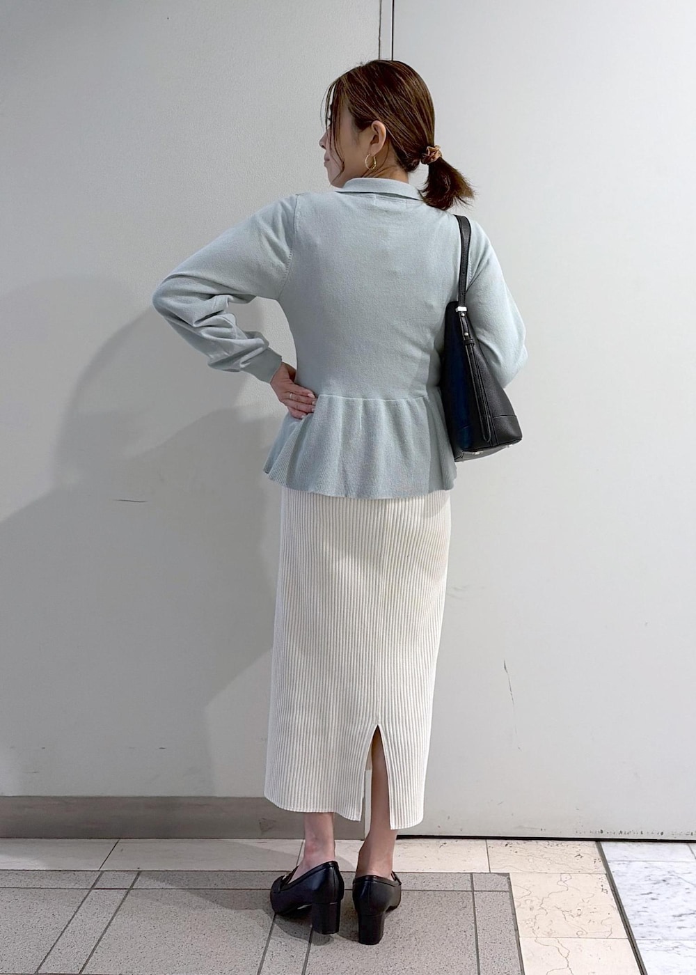 ブラック系のショルダーバッグ、ブラック系のローファー、ホワイト系のスカートを着用したレディースの春コーディネートの3枚目の写真