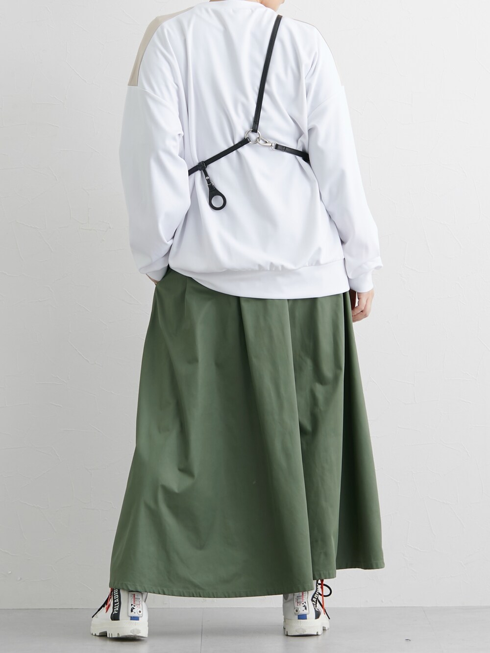 グリーン系のスカート、ホワイト系のTシャツ/カットソーを着用したレディースの冬コーディネートの2枚目の写真