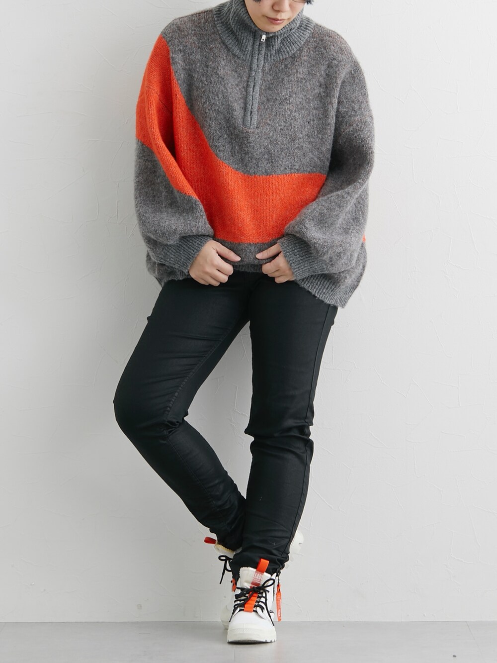 グレー系のニット/セーター、ブラック系のショルダーバッグを着用したレディースの冬コーディネートの2枚目の写真