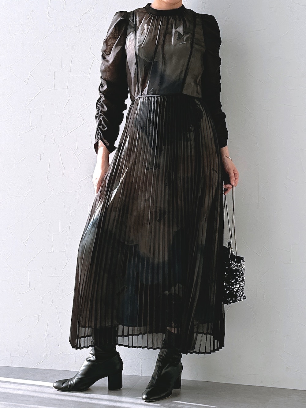 ブラック系のドレスを着用したレディースの春コーディネートの2枚目の写真