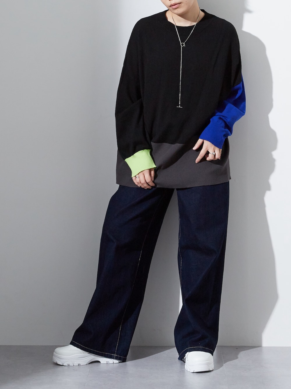 ブラック系のニット/セーター、ブルー系のデニムパンツを着用したレディースの夏コーディネートの2枚目の写真