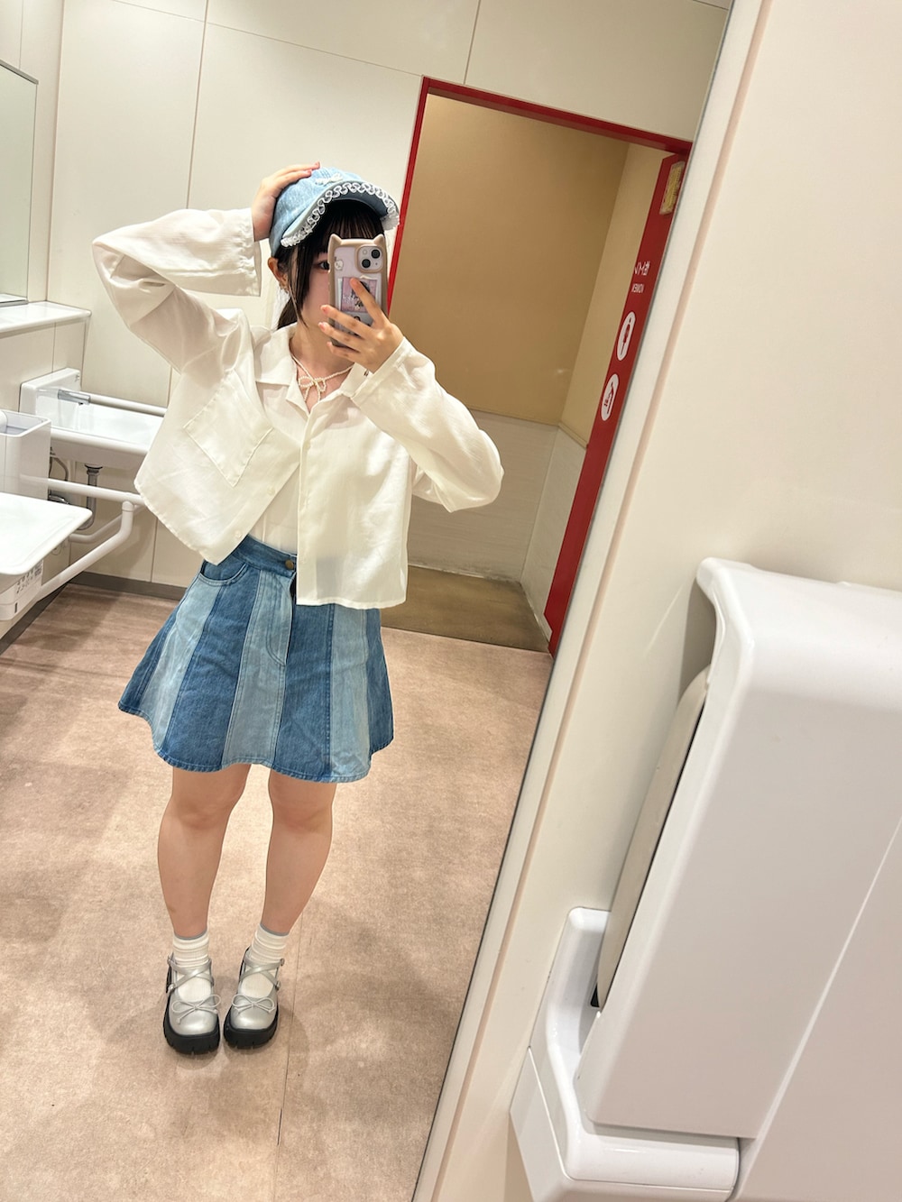 ブルー系のデニムスカート、シルバー系のパンプス、ホワイト系のカーディガン/ボレロを着用したレディースの春コーディネートの2枚目の写真
