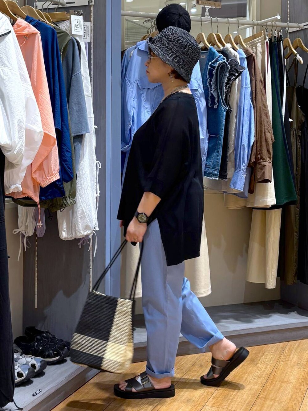 ブラック系のトートバッグ、その他のサンダル、ブルー系のその他パンツを着用したレディースの春コーディネートの4枚目の写真