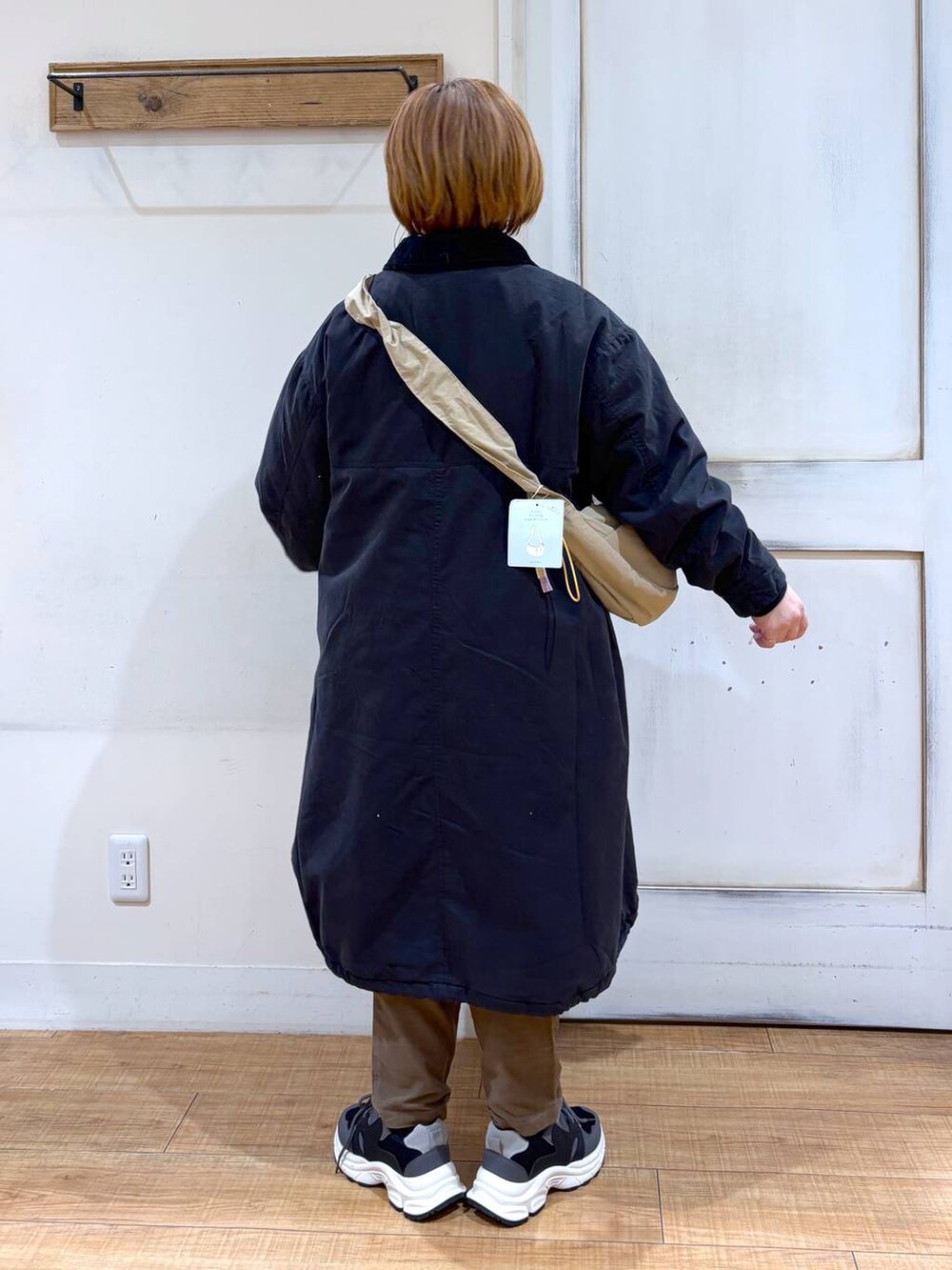 ブラウン系のその他パンツ、ブラック系のスニーカー、ベージュ系のショルダーバッグを着用したレディースの冬コーディネートの5枚目の写真