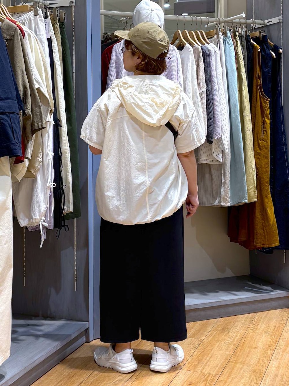 ブラック系のスカート、ホワイト系のスニーカー、その他のTシャツ/カットソーを着用したレディースの春コーディネートの5枚目の写真