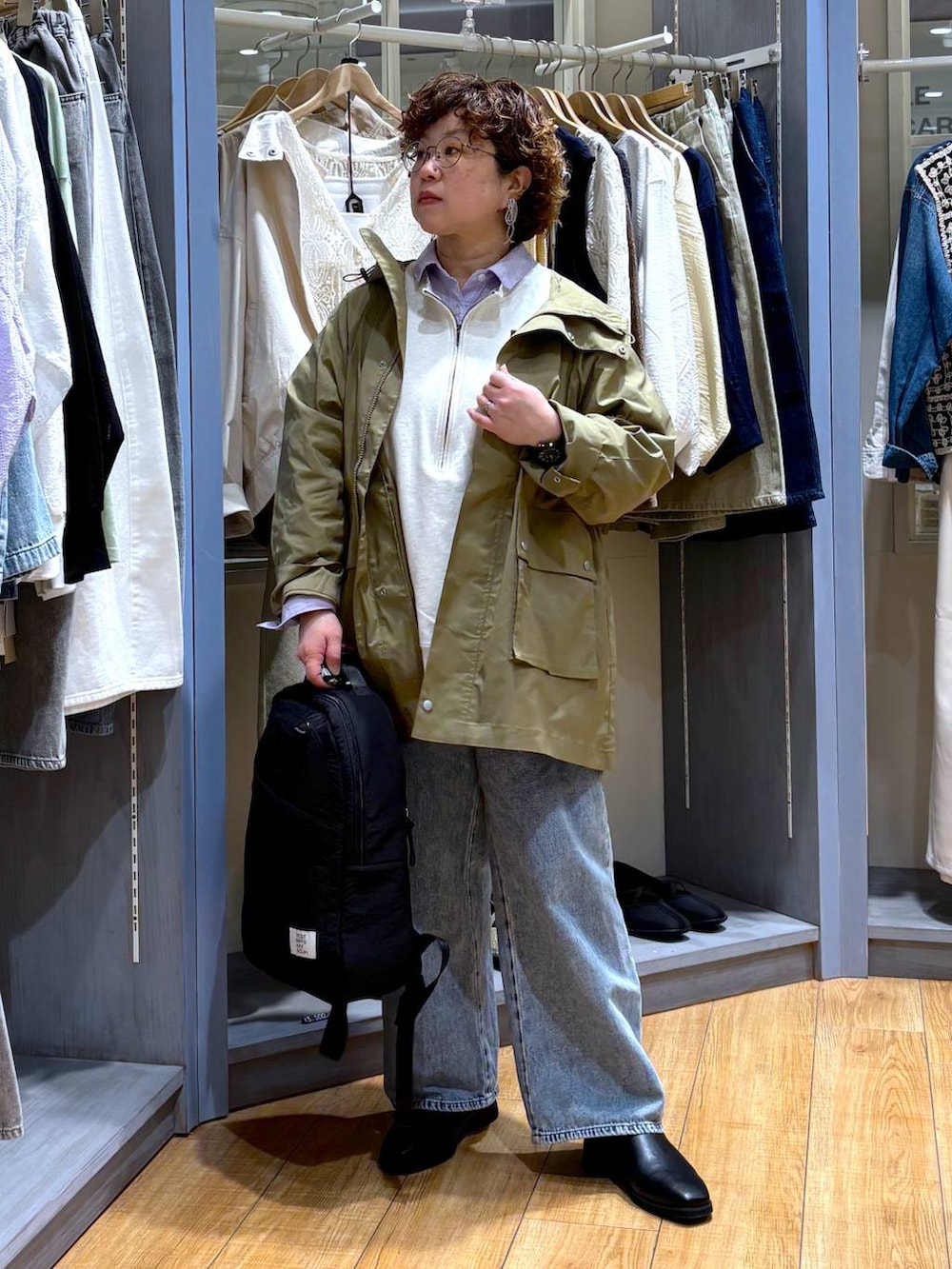 ベージュ系のスウェット、ブルー系のデニムパンツ、ベージュ系のブルゾンを着用したレディースの春コーディネートの2枚目の写真